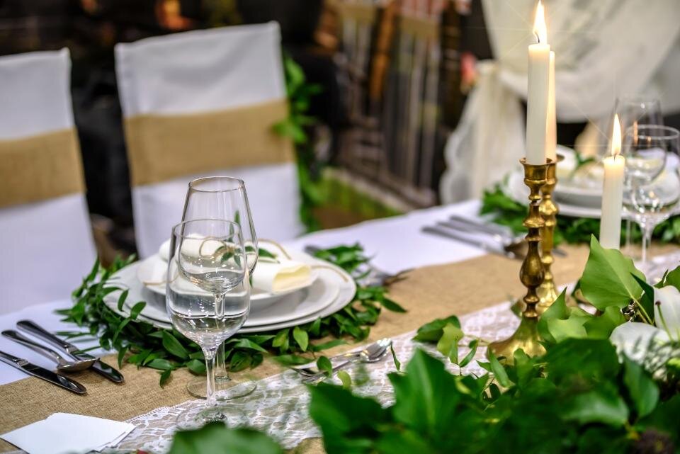 Lit white candles on a table covered with a white cloth